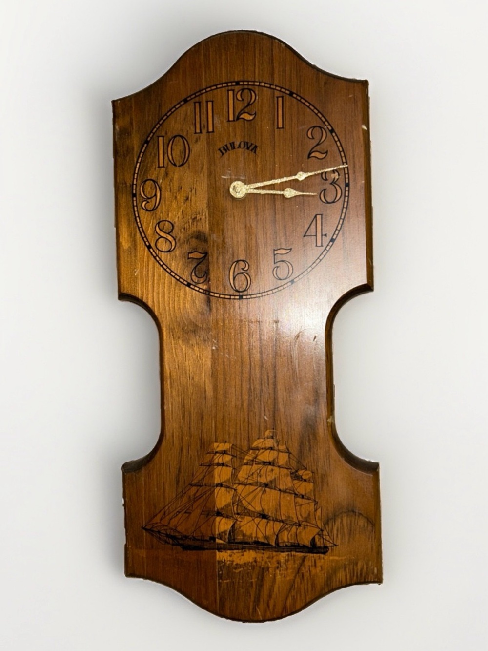Bulova wall clock features a unique wooden casing shaped like a stylized ship